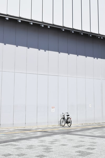 黑色通勤自行车停车场旁边的墙在白天

